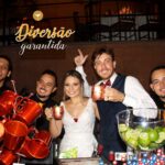 Noivos brindando com drinks junto aos Bartenders no casamento