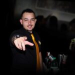 Bartender profissional em uma festa apontando para frente.