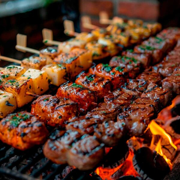 Churrasqueiro para festa: Espetinhos de carnes, linguiça e queijo assando na churrasqueira. Entre em contato e contrate um churrasqueiro profissional para sua festa.