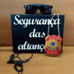 Maleta com letras em alto relevo com escrita "segurança das alianças". Distintivo, fone de ouvido e óculos escuro para hora das alianças.
