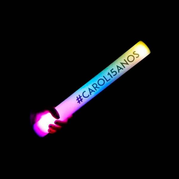 Mão segurando bastão de led personalizado. Está escrito no bastão de LED #carol15anos