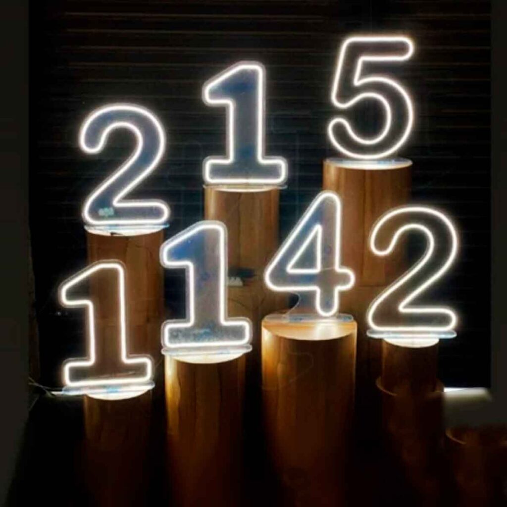 Números de led com luz acesa, seuqência de número na imagem 2, 1, 5, 1, 1, 4 e 2. Apesar desta sequência ilustrada você pode escolher entre 0 e 9 assim poderá comprar a idade do anivesariante.
