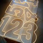 Números 1, 2 e 3 de LED espalhados em cima de uma mesa.