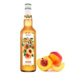 Garrafa de xarope de pêssego com a fruta pêssego cortada ao lado diretiro da garrafa de xarope para drinks. Compre agora!