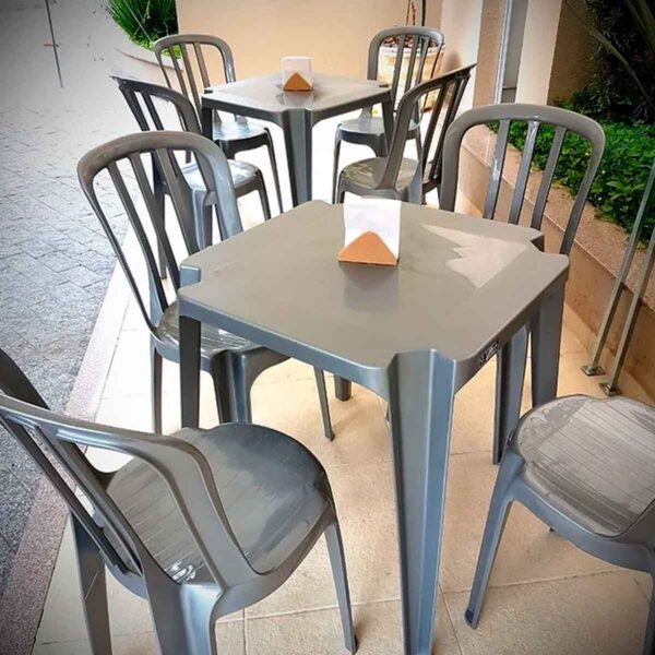 Mesas e cadeiras de plástico cinza empilháveis, ideais para alugar para festas e eventos em São Paulo.