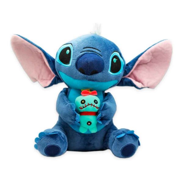 Pelúcia azul do personagem Stitch sentado e abraçando uma pequena boneca de vodu verde.