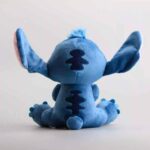 Pelúcia azul do personagem Stitch vista de costas, mostrando detalhes das costas e orelhas.