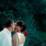 Filmagem de casamento em Curitiba: Casal de noivos se beijando com fundo verde.