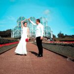Filmagem de casamento em Curitiba: Noivos dançando no Jardim Botânico, com a estufa ao fundo.