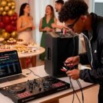 DJ com som do cliente conectando controladora e notebook ao som da casa em festa particular